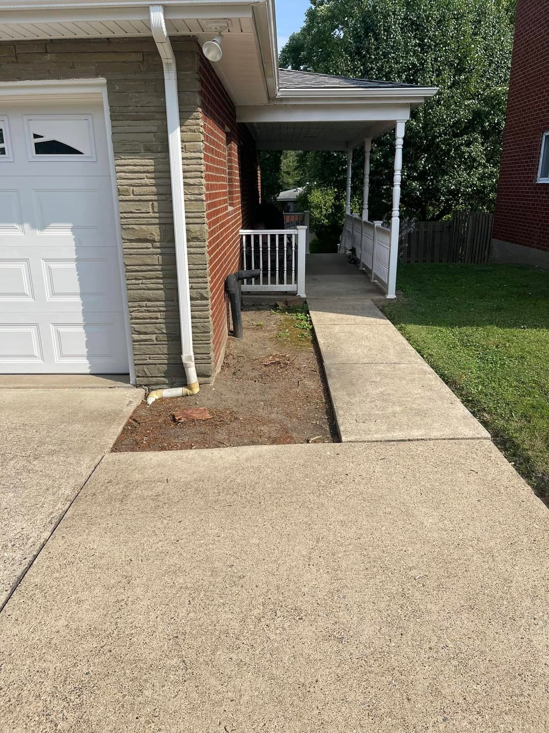 Residential home exterior showing driveway, porch, and landscaping details.