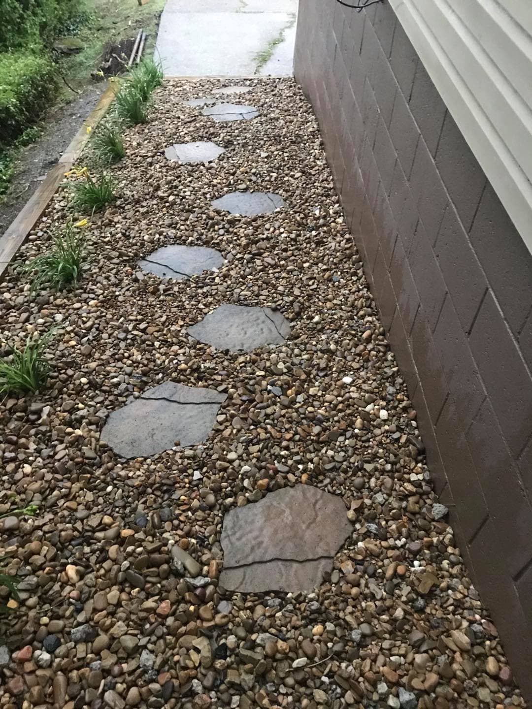 Pathway with stone steps and gravel landscaping beside a building.