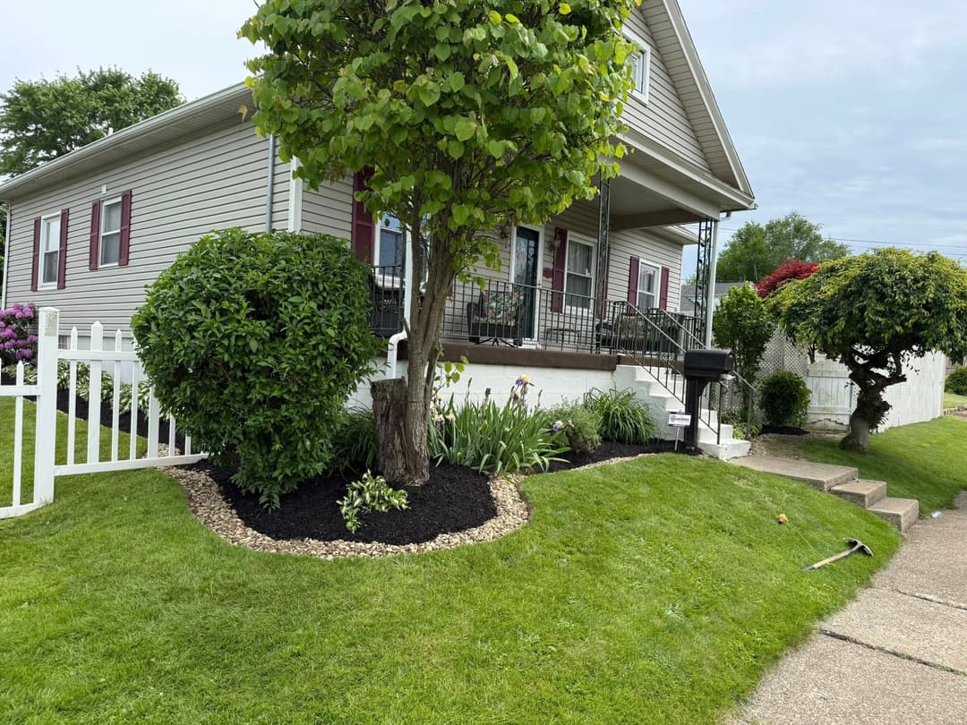 Charming house exterior with well-maintained garden and lush green lawn.
